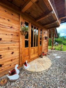 eine Holzhütte mit einer Tür und ein paar Schuhen draußen in der Unterkunft Drinska Villa Cabin in Perućac