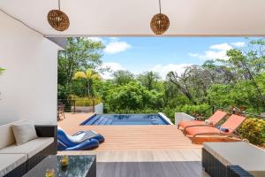 an open living room with a pool and a patio at Villa with Minimalist Design & Scenic Deck with Private Infinity Pool and Jungle Views in Coco