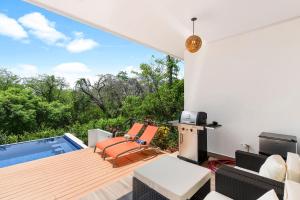 a patio with chairs and a swimming pool at Villa with Minimalist Design & Scenic Deck with Private Infinity Pool and Jungle Views in Coco