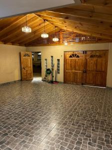 an empty room with wooden doors and a stone floor at casa in La Chimba