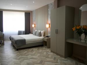 The Roomy Hotel Nişantaşı في إسطنبول: غرفة فندقية بسرير ونافذة كبيرة
