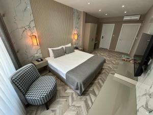 um quarto de hotel com uma cama e uma cadeira em The Roomy Hotel Nişantaşı em Istambul