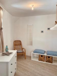 Habitación blanca con cama y silla en Le petit By Gargà Residency en Peschici