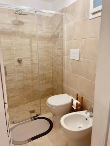 y baño con ducha, aseo y lavamanos. en Le petit By Gargà Residency en Peschici