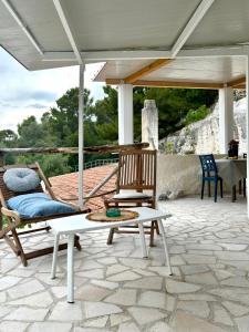 a patio with two chairs and a table and an umbrella at Le petit By Gargà Residency in Peschici