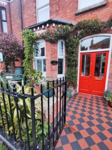 a red door on a brick building with a fence at Acara House B&B in Dublin