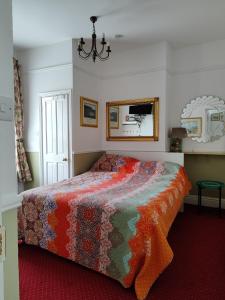um quarto com uma cama com um cobertor colorido em Acara House B&B em Dublin