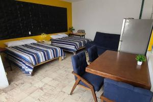 a room with two beds and a table and a chalkboard at Casa Habitación Frida Valentina in Tequila