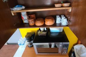 a small kitchen with a microwave and some food at Casa Habitación Frida Valentina in Tequila