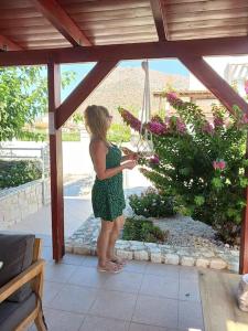 a woman standing on a patio looking at flowers at On the Beach in Stavros +20 photos