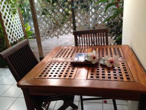 d'une table en bois avec une assiette et des fleurs. dans l'établissement Bungalow Takaya Bambou, à Saint-François