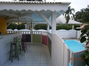 un bar en la piscina con piscina y una valla blanca en Bungalow Takaya Bambou, en Saint-François