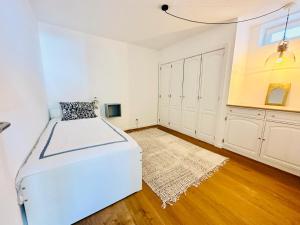 una camera bianca con letto e pavimento in legno di Villa Nola Cascais a Cascais Altre 9 foto
