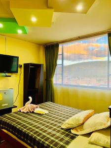 - une chambre avec un lit et une grande fenêtre dans l'établissement Dos Hemisferios, à Quito