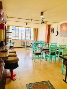 un restaurant avec des tables et des chaises vertes dans une salle dans l'établissement Dos Hemisferios, à Quito