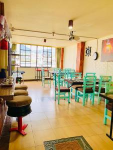 un ristorante con tavoli e sedie verdi in una stanza di Dos Hemisferios a Quito