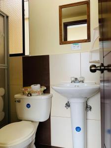 La salle de bains est pourvue de toilettes et d'un lavabo. dans l'établissement Dos Hemisferios, à Quito