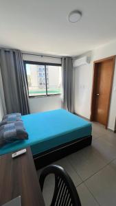 ein Schlafzimmer mit einem blauen Bett und einem Fenster in der Unterkunft AP Cantinho baiano Ilhéus Ba in Ilhéus