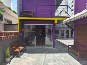 布盧梅瑙的住宿－Pousada Casa da Maga - Vila Germânica，两席坐在紫色建筑外