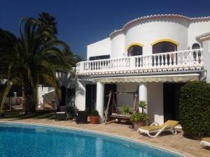 a villa with a swimming pool in front of a house at Villa Tobias in Carvoeiro