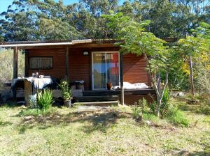 a cabin with a dog laying on the porch at Cabaña Pitiayumí in Villa Serrana