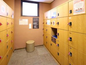 a row of lockers in a classroom with a window at Dormy Inn Express Mikawaanjo in Anjomachi