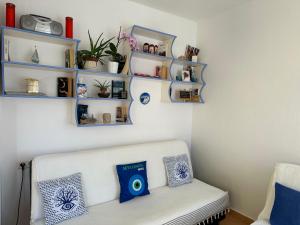 ein Wohnzimmer mit einem weißen Sofa und blauen Regalen in der Unterkunft Kristi Apartment in Sarandë