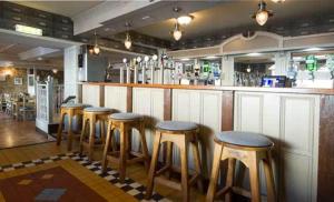 um bar com uma fila de bancos num restaurante em The Tailor's House Guest Rooms em Dunmoyle