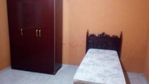 a bedroom with a bed and a wooden cabinet at Rancho do Carlinhos in Ipoema