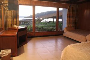 una habitación de hotel con una cama y una ventana grande en Hotel El Camino Real, en Aquitania 27 fotos más