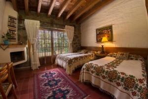 een slaapkamer met 2 bedden en een raam bij Hotel Rancho San Cayetano in Zitácuaro