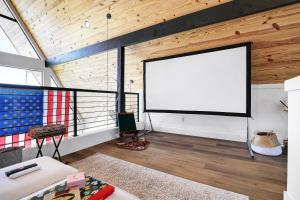 una sala de estar con una gran pantalla en el techo en Casa De Gruene Retreat, en New Braunfels