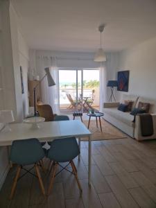 a living room with a table and chairs and a couch at Apartamentos Dom Henrique in Monte Gordo