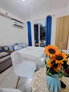 a living room with a table with a vase of sunflowers at MaryneL Suites in Suba