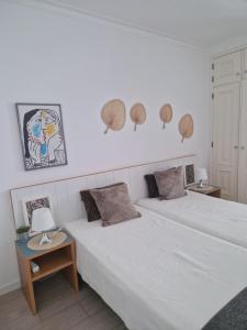 1 Schlafzimmer mit 2 Betten und 2 Tischen mit Lampen in der Unterkunft Apartamentos Dom Henrique in Monte Gordo
