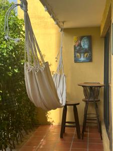 a hammock hanging on a patio with a table at Santa Marta La Magia De Tenerlo Todo in Santa Marta