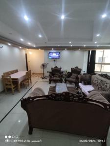 a living room with a large couch and a tv at شقة مفروشة رائعة كورنيش النيل برج الرياض in Naj‘ al ‘Amrāb