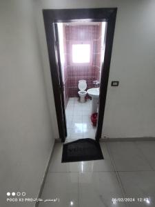 a bathroom with a toilet and a door with a window at شقة مفروشة رائعة كورنيش النيل برج الرياض in Naj‘ al ‘Amrāb