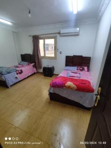 a bedroom with two beds and a window at شقة مفروشة رائعة كورنيش النيل برج الرياض in Naj‘ al ‘Amrāb