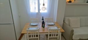 uma mesa de jantar com cadeiras e uma garrafa de vinho em Vivienda vacacional a 10 minutos de la capital. em Arucas