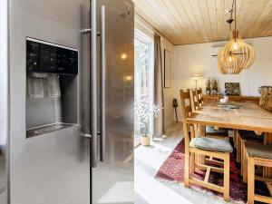 Il comprend une cuisine et une salle à manger avec un réfrigérateur et une table. dans l'établissement 8 person holiday home in Storvorde, à Storvorde 43 autres photos