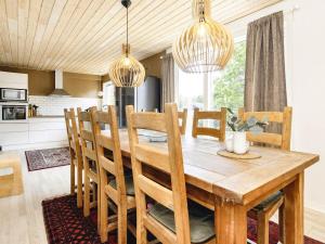 une cuisine et une salle à manger avec une table et des chaises en bois dans l'établissement 8 person holiday home in Storvorde, à Storvorde