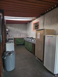 a kitchen with two refrigerators and a trash can at Cabana Hostel nas Árvores EcoPark in São Pedro