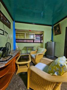 a living room with wicker chairs and a tv at Bohol Sea Breeze Cottages and Resort in Panglao