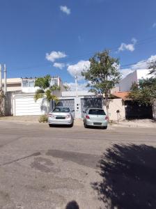 dos autos estacionados en un estacionamiento frente a un edificio en Casa de Dois Quartos, en Boituva