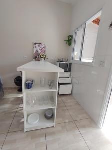 eine kleine Küche mit einer weißen Theke in einem Zimmer in der Unterkunft Casa de Dois Quartos in Boituva
