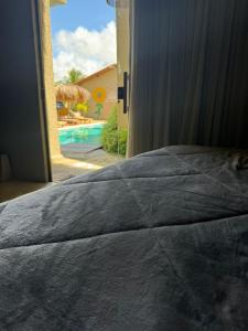 a bedroom with a bed with a view of a pool at Nauru chalés milagres in São Miguel dos Milagres