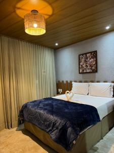 Un dormitorio con una cama grande y una lámpara de araña. en Nauru chalés milagres, en São Miguel dos Milagres