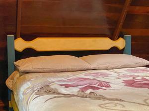 uma cama com cabeceira e almofadas de madeira em Chalé Floresta Amada em Ouro Preto
