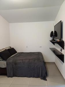 a bedroom with a bed and a flat screen tv at casa com bela vista em itatiba in Tijuco Prêto